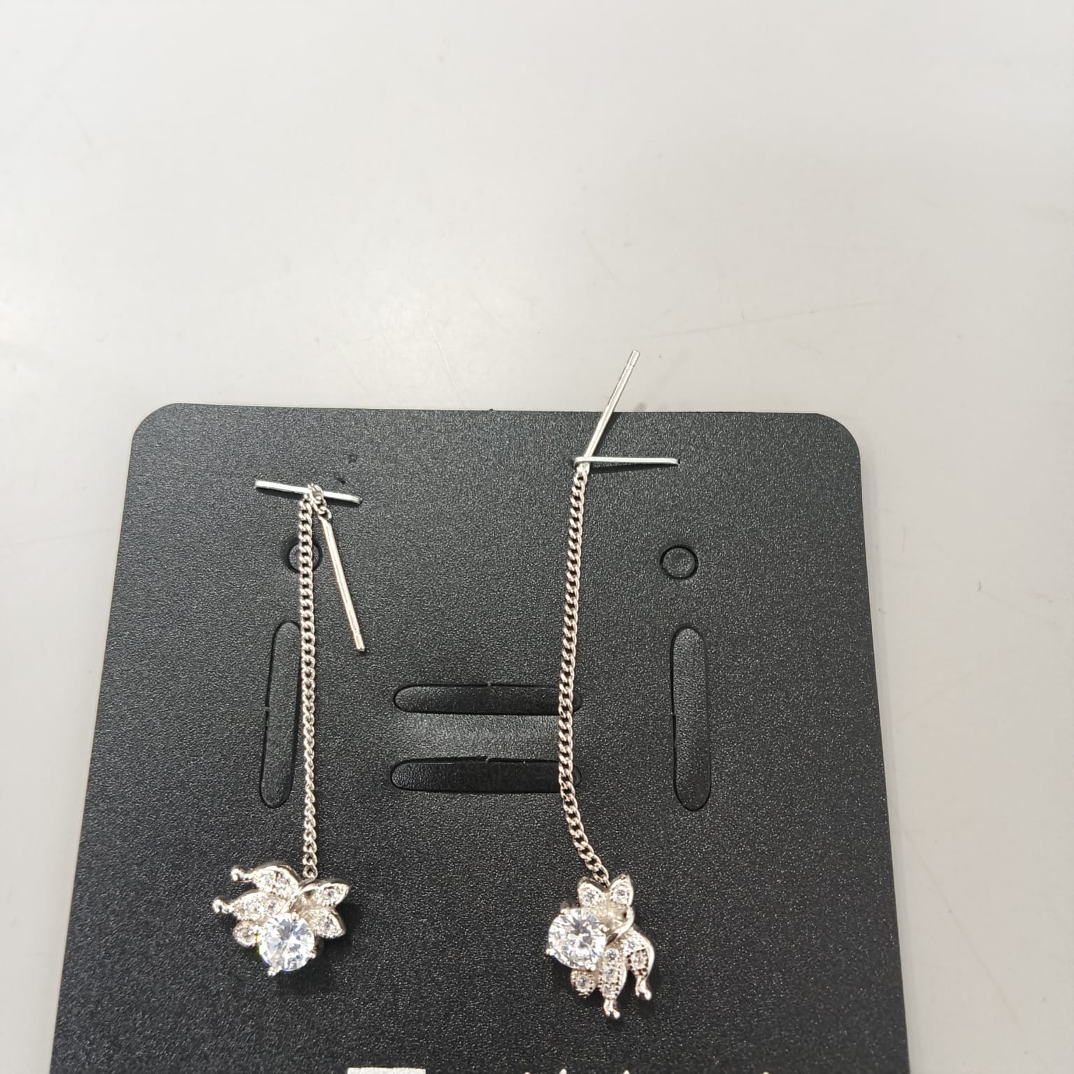 925 sterling silver Sui Dhaga earring with leaf bloom and round clear centre, shown from front and side.
