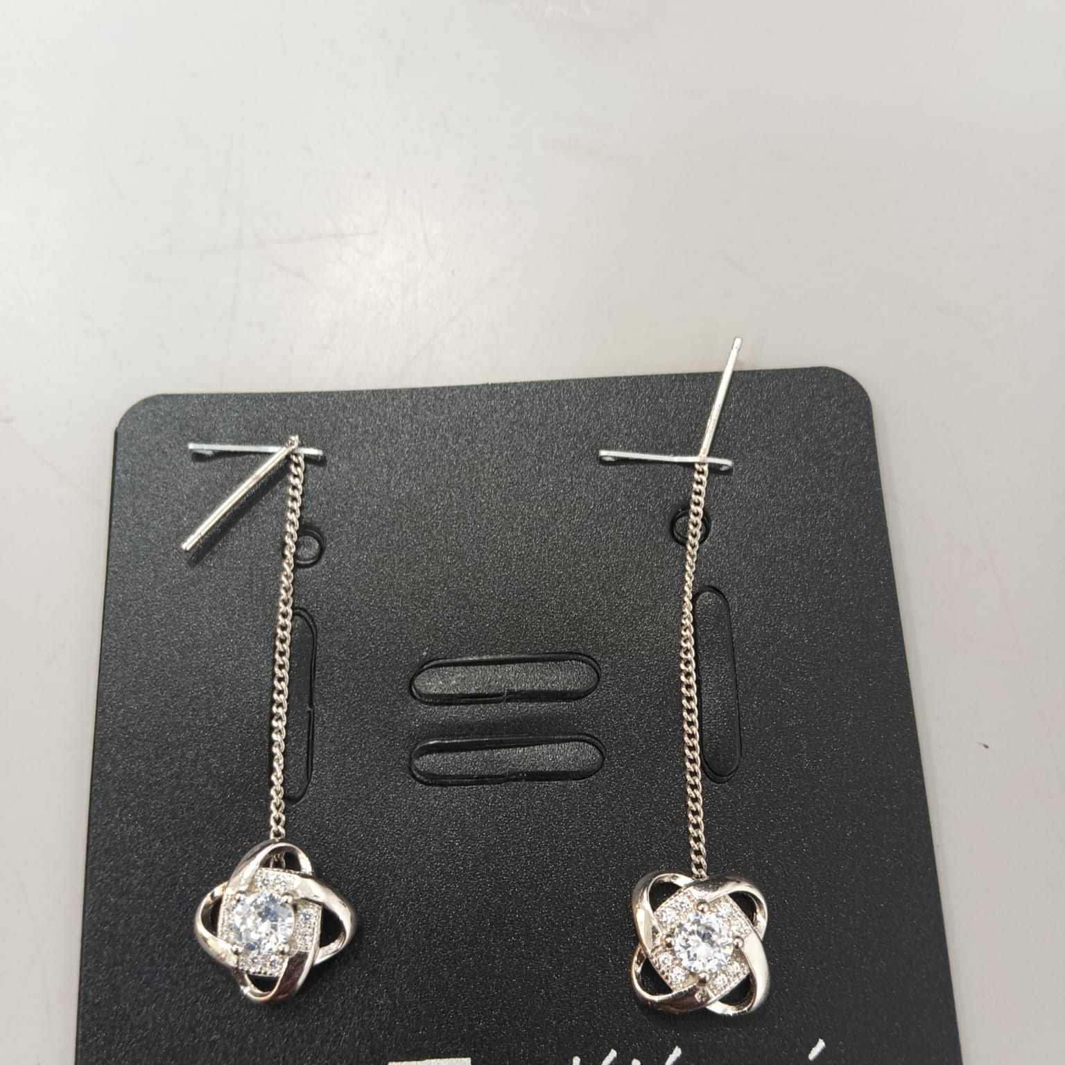 925 sterling silver Sui Dhaga earring with interlaced halo and clear centre, shown from front and side.