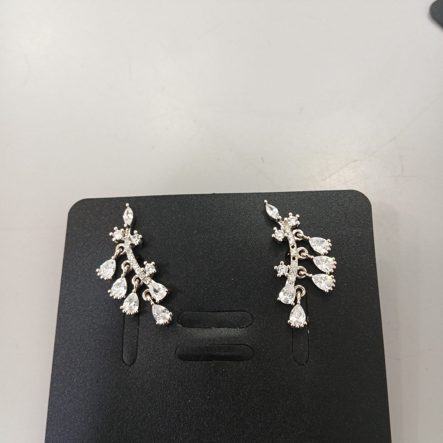 925 sterling silver ear climbers with a curved clear-accented bar, leafy details and four pear-shaped drops.