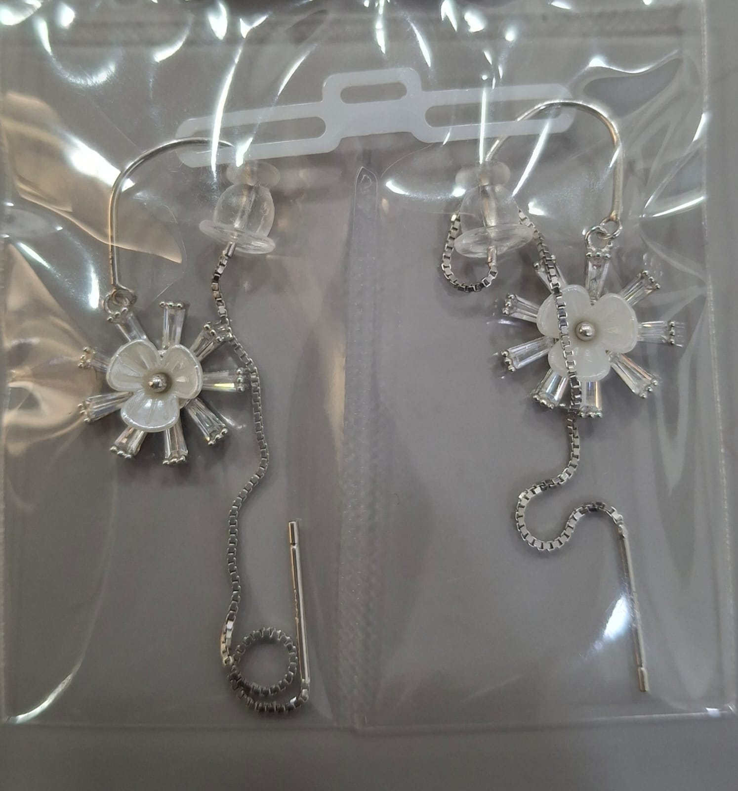 925 sterling silver Sui Dhaga earring with ivory-toned bloom and baguette rays, shown from front and side.