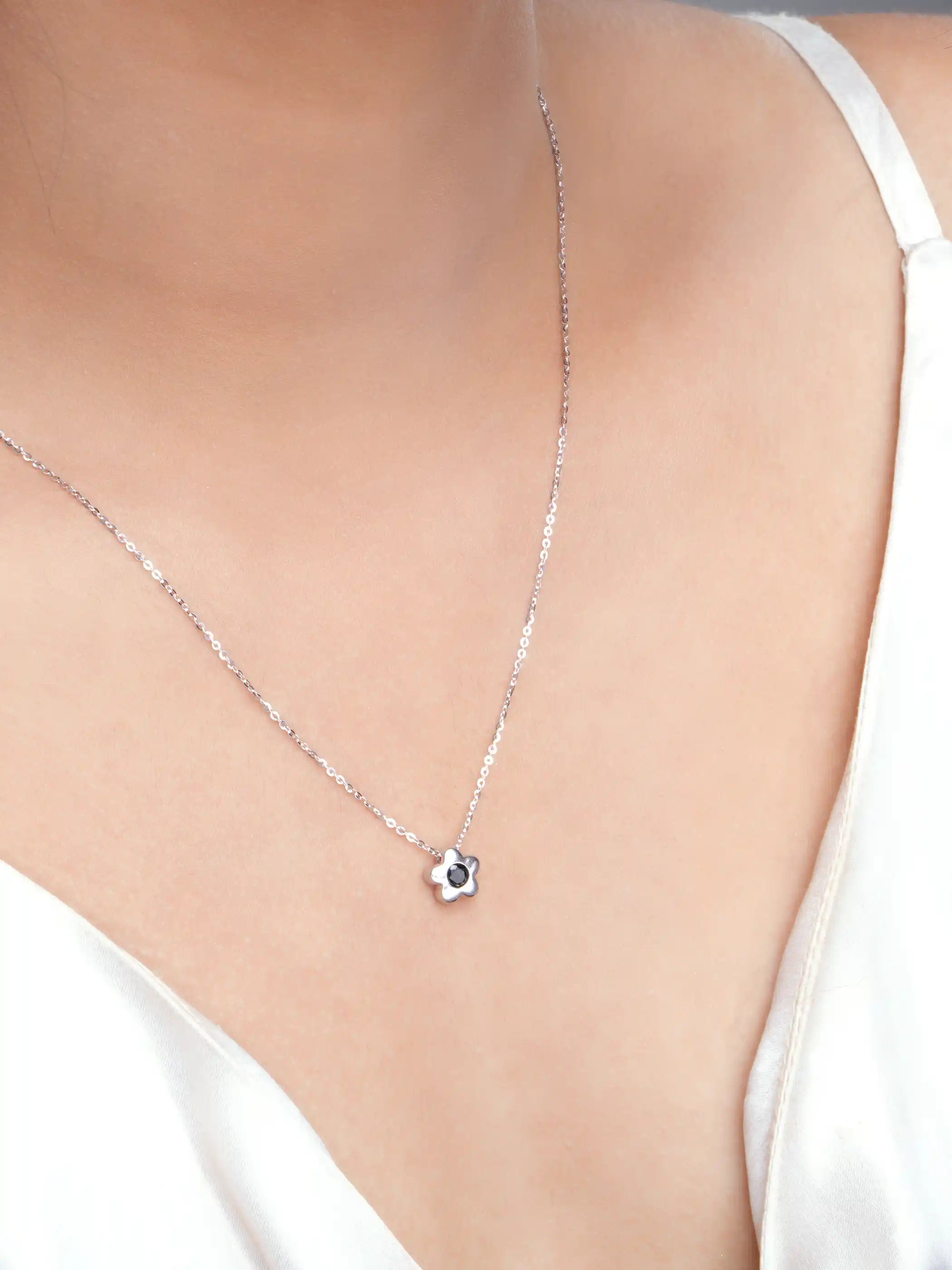 925 silver flower pendant necklace with black stone centerpiece on a fine chain