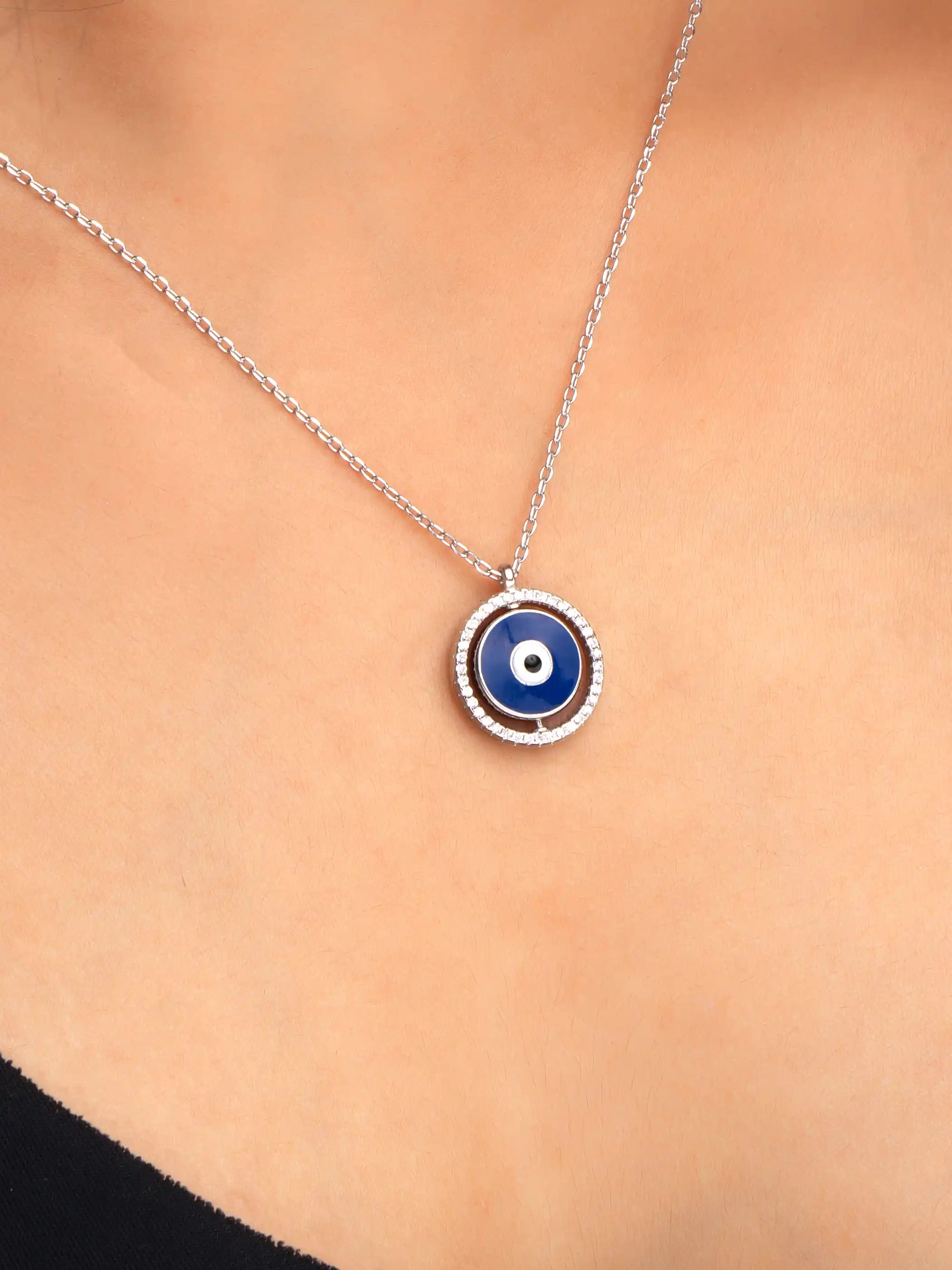 925 silver necklace with round blue evil eye pendant framed in silver detailing, symbolizing protection and modern elegance