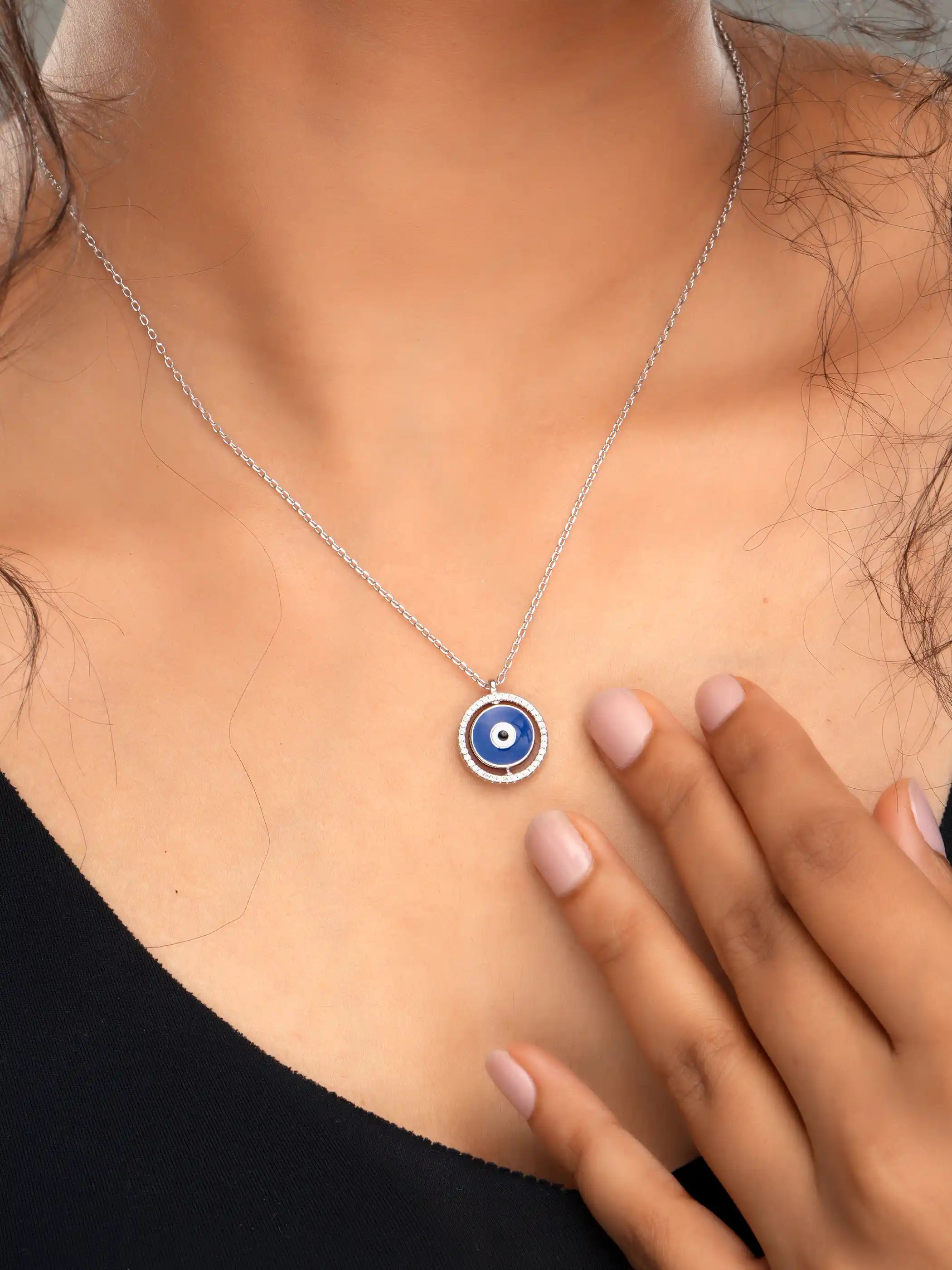 925 silver necklace with round blue evil eye pendant framed in silver detailing, symbolizing protection and modern elegance