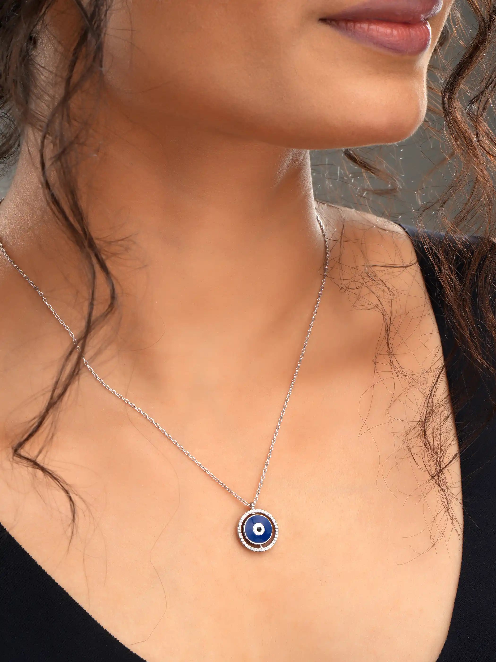 925 silver necklace with round blue evil eye pendant framed in silver detailing, symbolizing protection and modern elegance