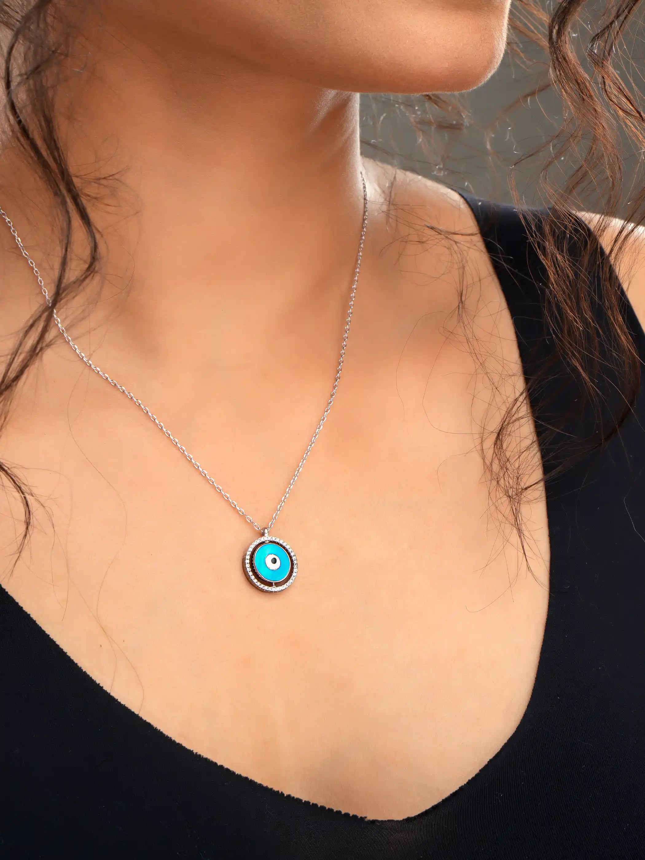925 silver necklace with round blue evil eye pendant framed in silver detailing, symbolizing protection and modern elegance