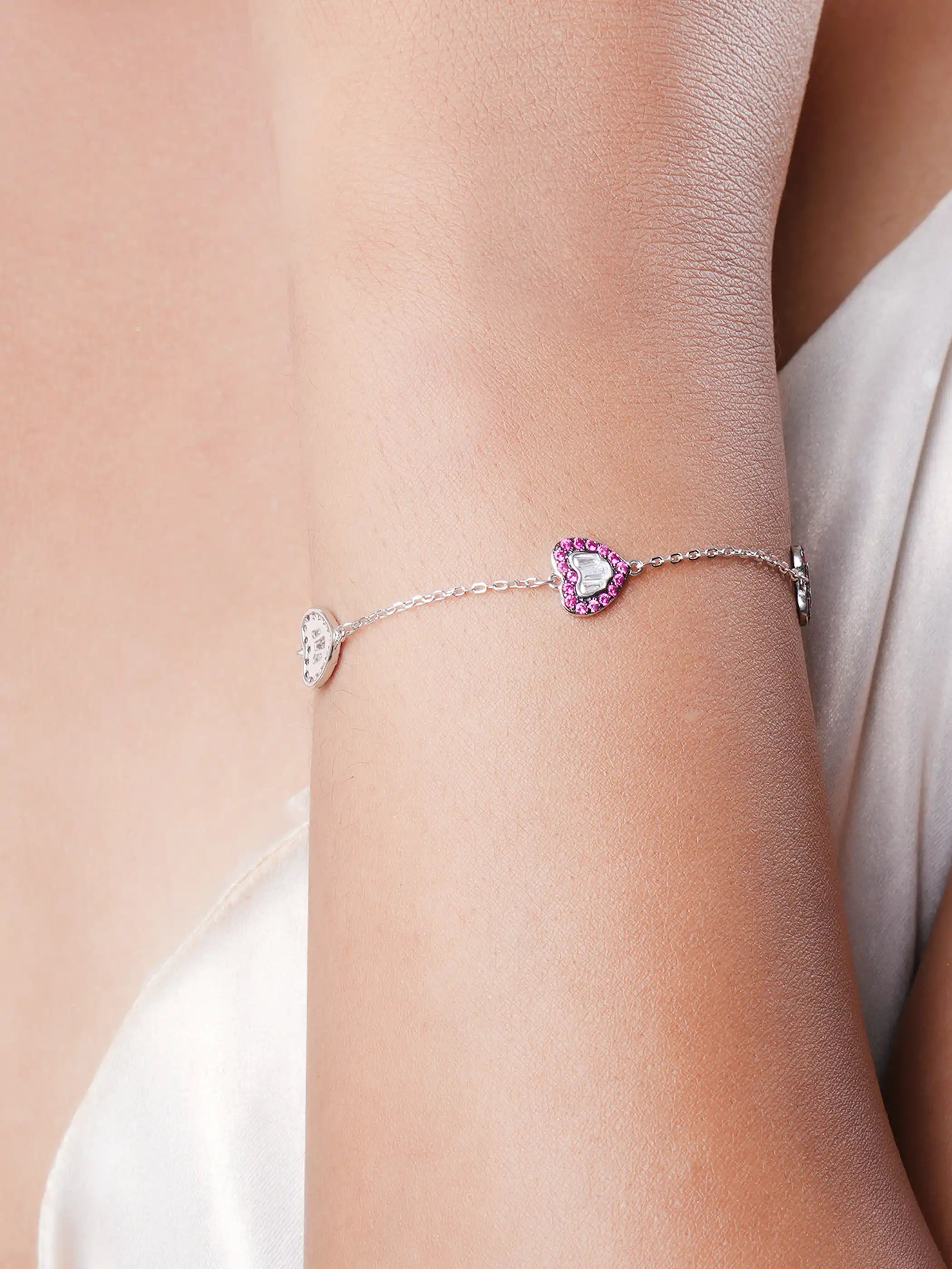925 silver bracelet with three pink crystal-studded heart charms featuring silver detailing on delicate chain