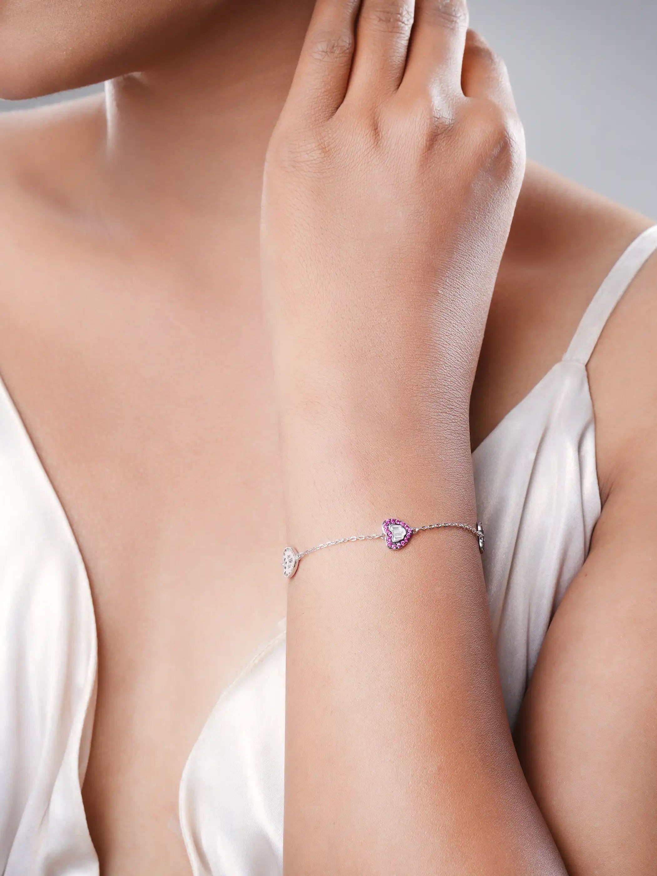 925 silver bracelet with three pink crystal-studded heart charms featuring silver detailing on delicate chain
