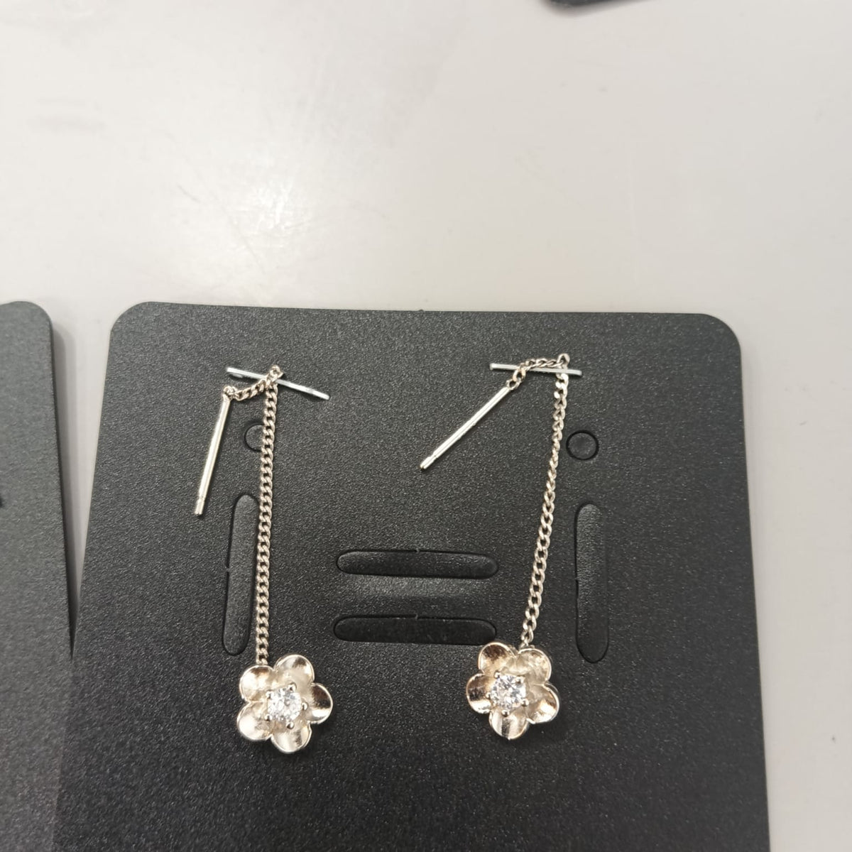 925 sterling silver Sui Dhaga earring with brushed five-petal flower, shown from front and side.