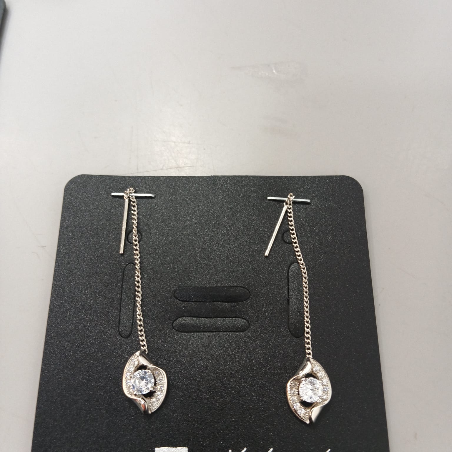 925 sterling silver Sui Dhaga earring with sculpted leaf and clear centre, shown from front and side.