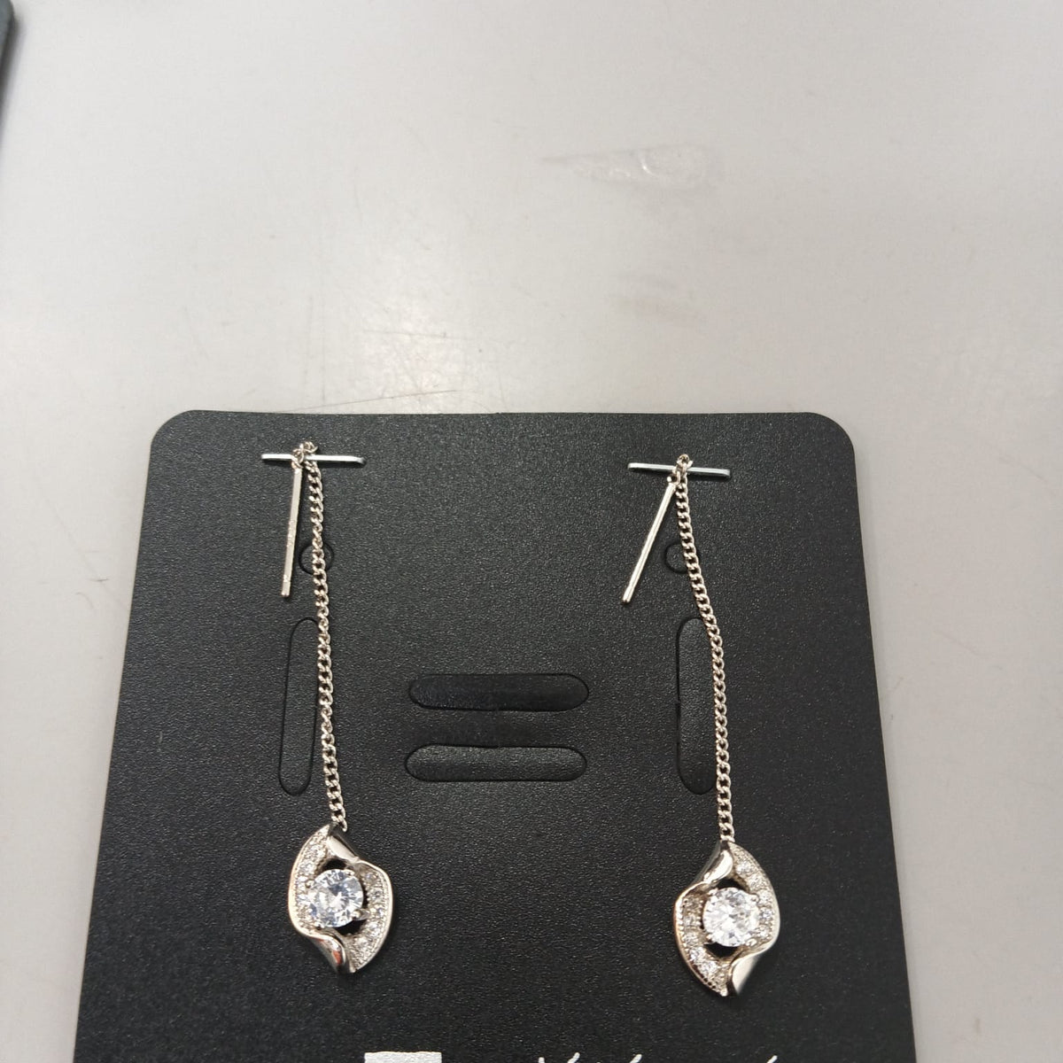 925 sterling silver Sui Dhaga earring with sculpted leaf and clear centre, shown from front and side.