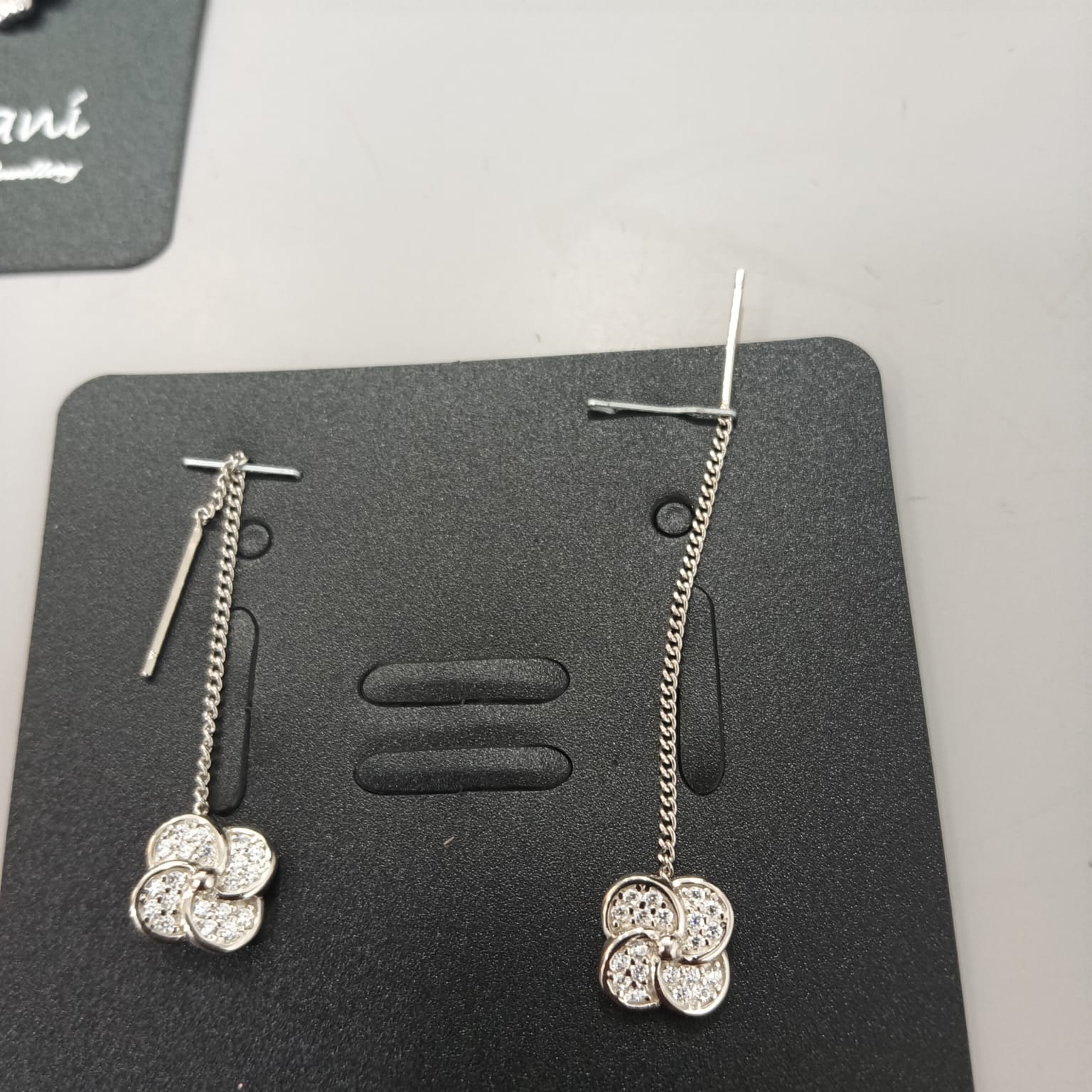 925 sterling silver Sui Dhaga earring with stone-set four-lobed pinwheel, shown from front and side.