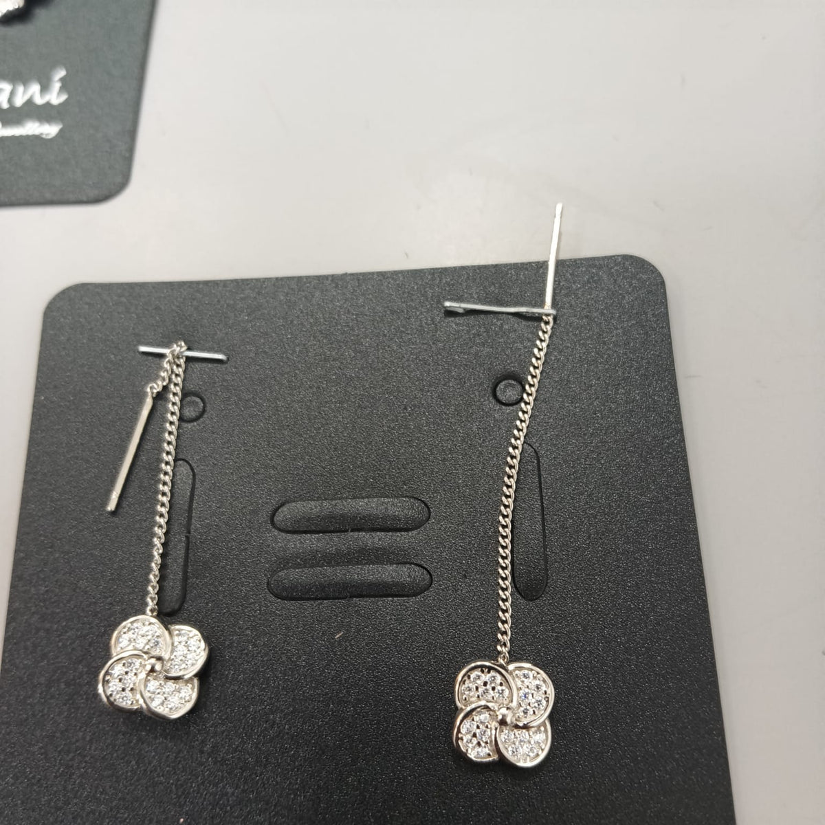 925 sterling silver Sui Dhaga earring with stone-set four-lobed pinwheel, shown from front and side.