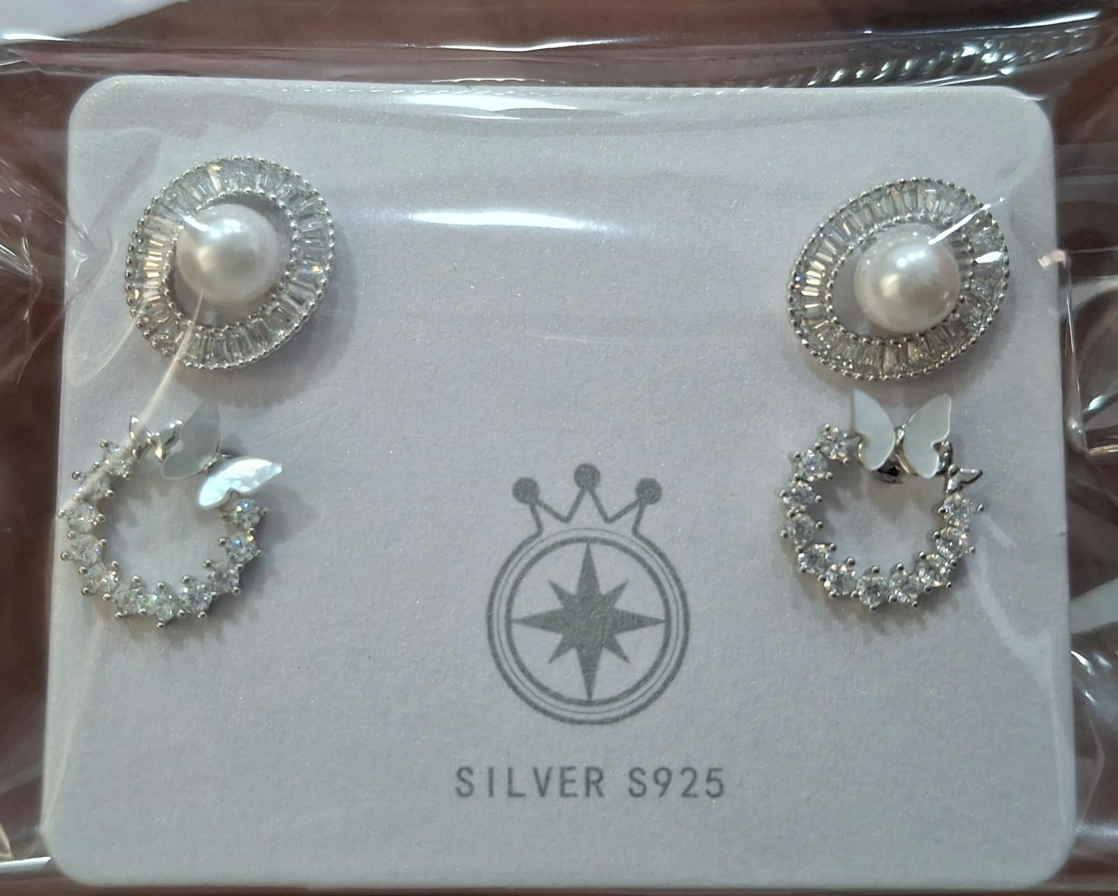 925 sterling silver two-pair stud earrings with ivory-toned sunbursts and pale butterfly wreaths, front and side views.