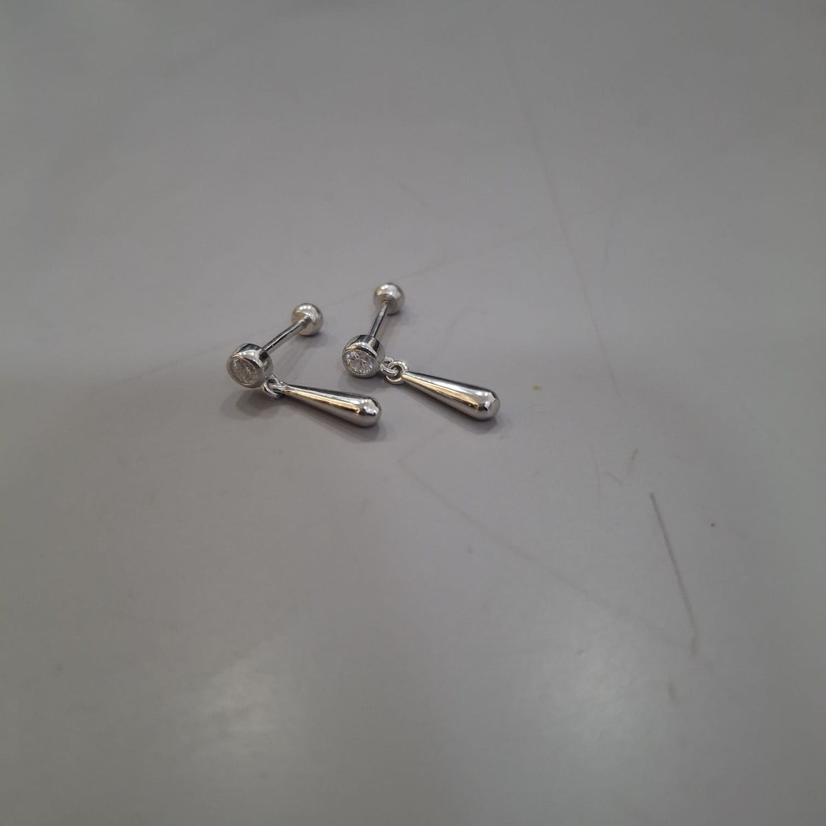 925 sterling silver drop earrings with round clear-stone stud and a smooth elongated teardrop, front and side views.