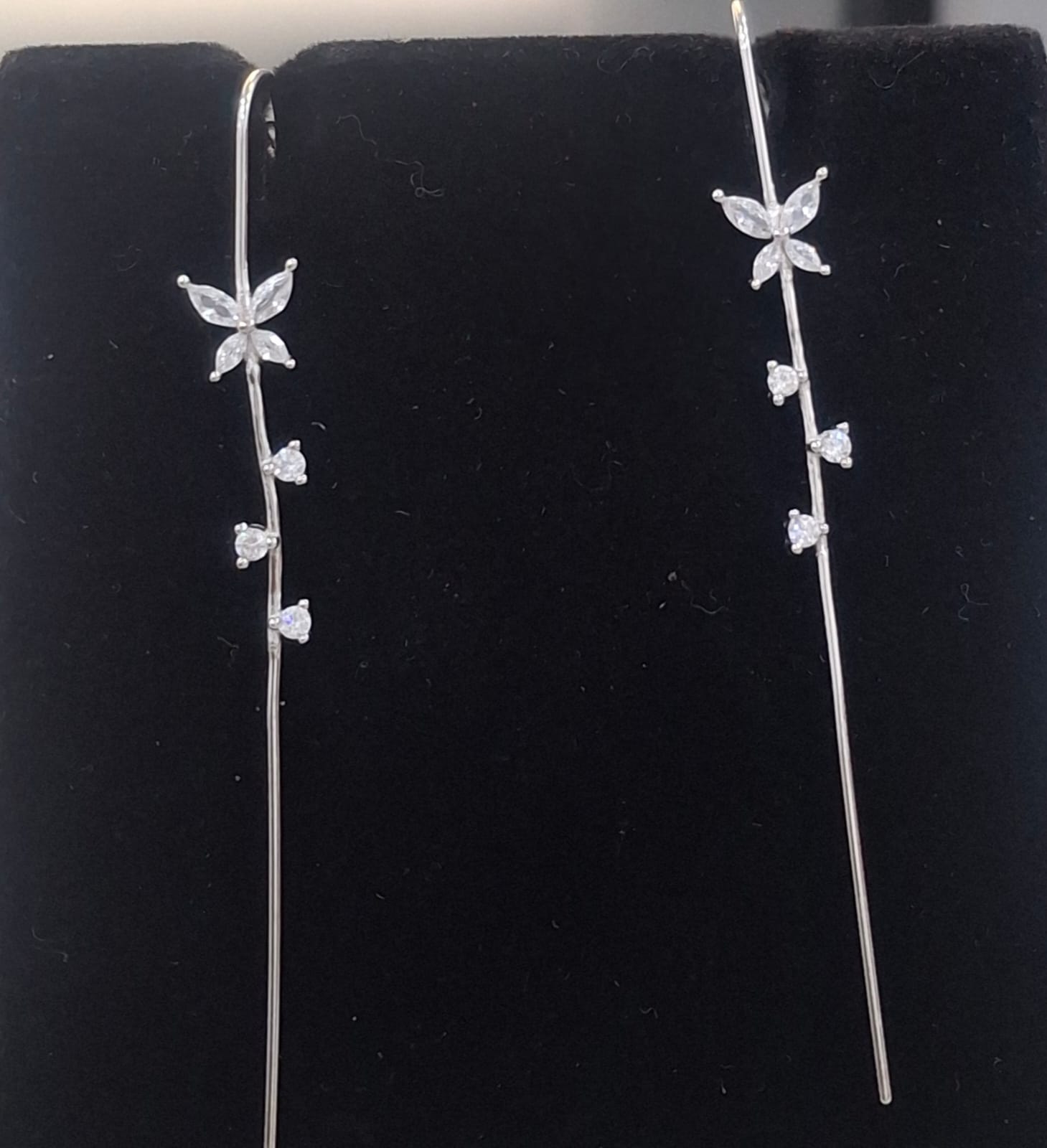 925 sterling silver ear needle pin with floral motif and triangular stone trail, shown from front and side.