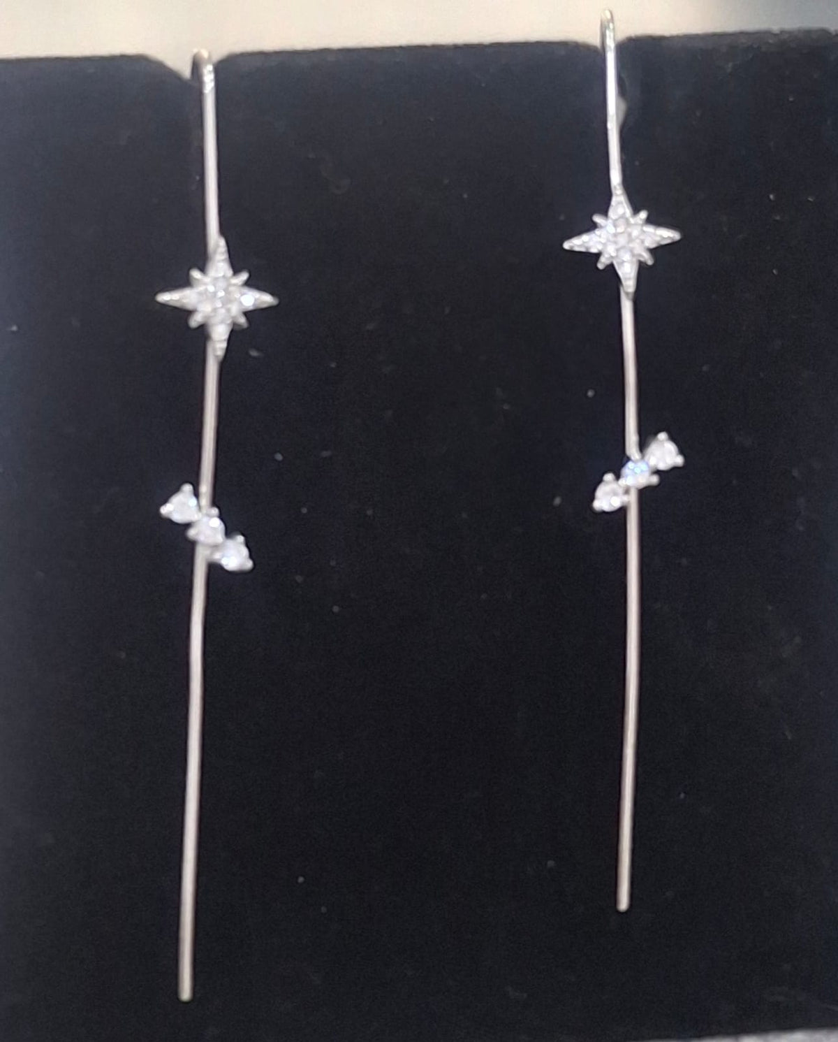 925 sterling silver ear needle pin with compass star and three-stone trail, shown from front and side.