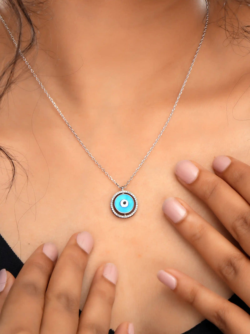 925 silver necklace with round blue evil eye pendant framed in silver detailing, symbolizing protection and modern elegance